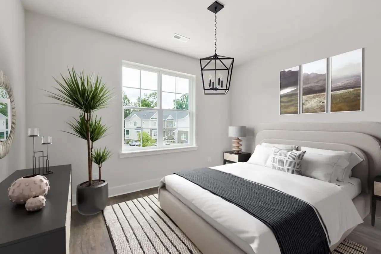 Same room virtually staged as a bedroom with a bed, bedside tables and dresser