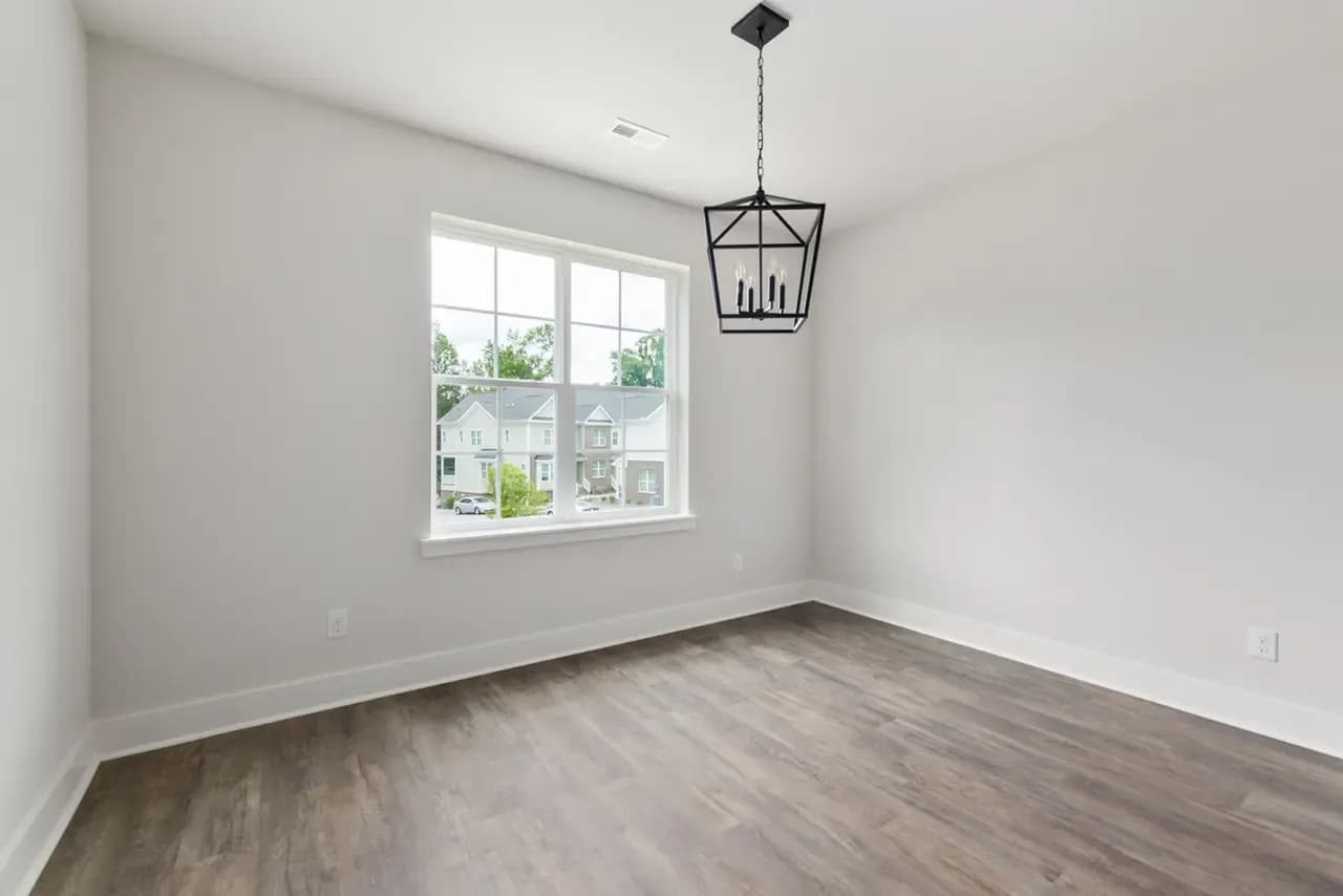Empty room with a single window and pendant light before virtual staging