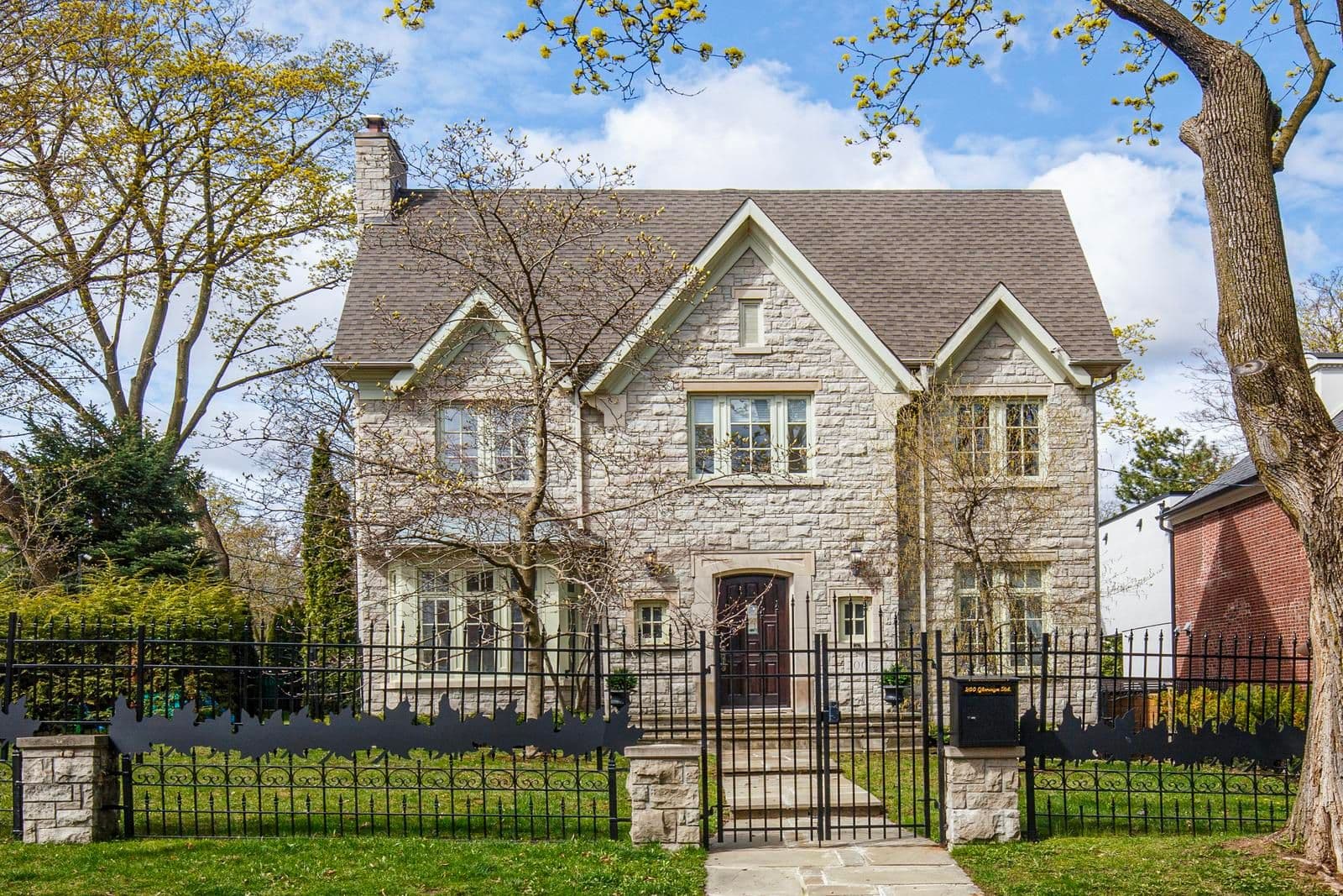 Stone-front house behind a wrought-iron fence at 200 Glenayr Road, Toronto