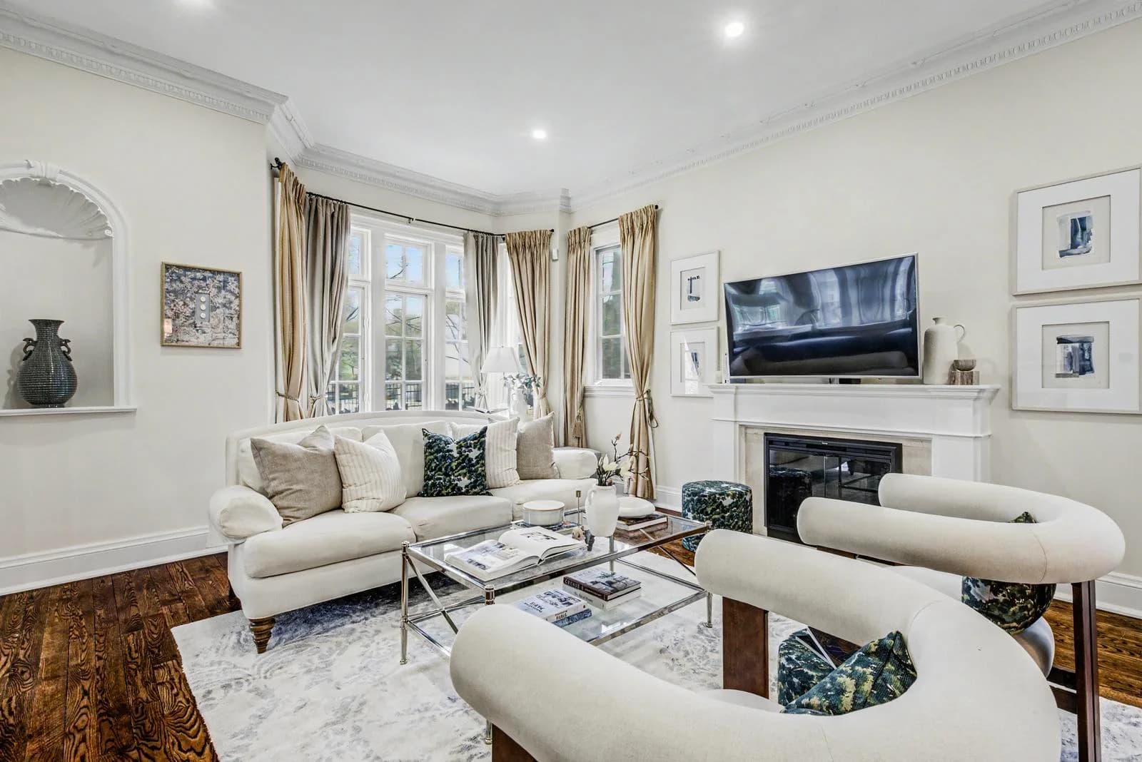 Living room with a bay window, glass coffee table and fireplace at 200 Glenayr Road
